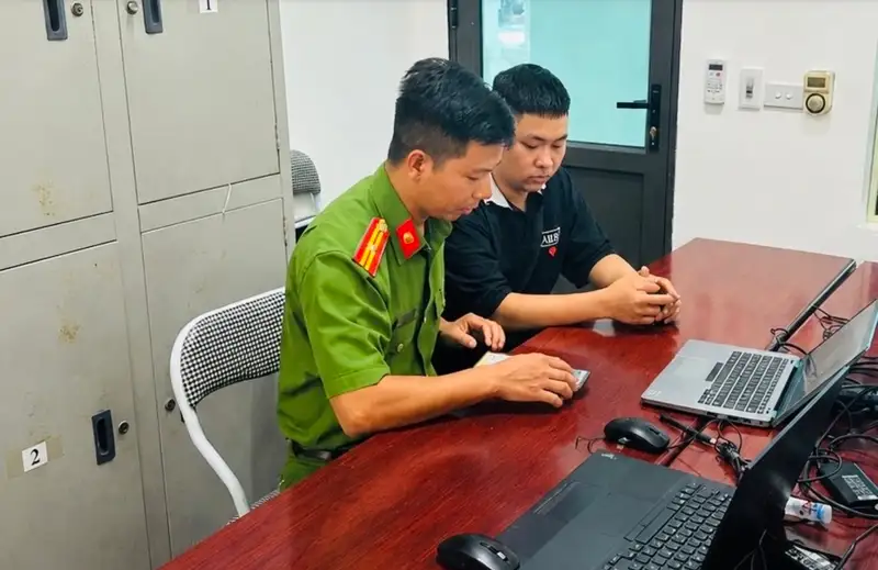 Police officers guide a resident on cybersecurity measures